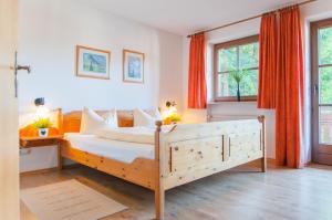 a bedroom with a large bed with orange curtains at Am Sonnenhang in Ruhpolding