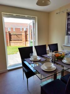 a dining room with a table and chairs and a window at Lakeside: Argosy 3bed house 2bath parking M27 J5 Southampton Airport sleeps 6 in Southampton