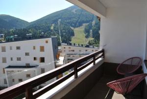 a balcony with two chairs and a view of a mountain at Apartman Nai in Bjelašnica