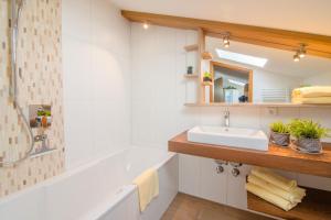 a bathroom with a tub and a sink at Am Sonnenhang inkl. Chiemgaukarte in Ruhpolding +65 photos