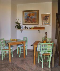 una sala da pranzo con sedie verdi e tavolo di La Corte del Macero a Castelfranco Emilia