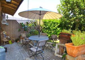 a patio with a table and chairs and an umbrella at La Corte del Macero in Castelfranco Emilia