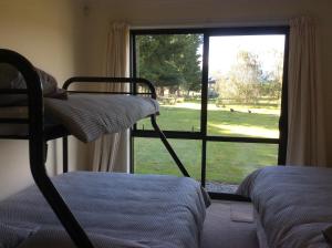 a bedroom with bunk beds and a window with a view of a yard at Oxford Holiday Cottage in Oxford