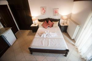 a bedroom with a large bed with two lamps at Afrodite Hotel Apartments in Myrina