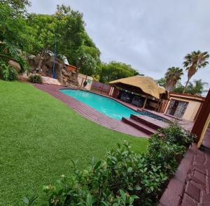 a swimming pool in a yard next to a house at Ethen Guesthouse in Polokwane