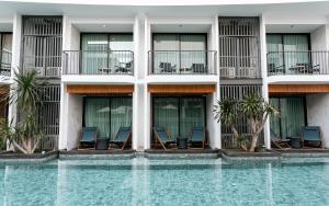 a hotel with chairs and a swimming pool at Wintree City Resort in Chiang Mai
