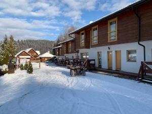 a motorcycle parked in the snow next to a building at SKI CIERNY BALOG in Čierny Blh