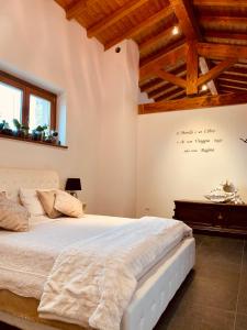 een slaapkamer met een groot bed en houten plafonds bij AGRITURISMO BOSCO LONGHINO in Santa Maria della Versa