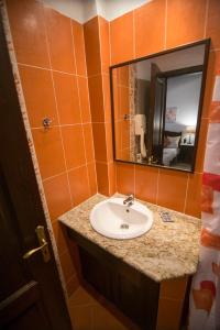 a bathroom with a sink and a mirror at Afrodite Hotel Apartments in Myrina