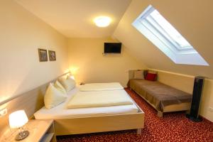 a small bedroom with a bed and a window at Landhotel Gasthof Bauböck in Andorf