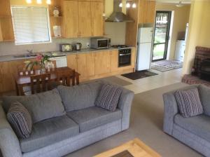 a living room with a couch and a kitchen at Oxford Holiday Cottage in Oxford