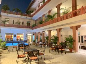 an outdoor patio with tables and chairs and a pool at Suryaa Villa - A Boutique Heritage Hotel in Jaipur