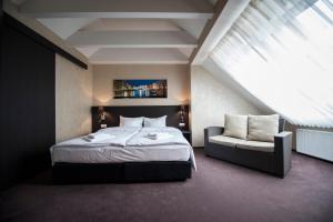 Un dormitorio con una cama y un sofá y una ventana. en Markus, en Kolonowskie 28 fotos más