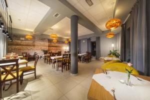 ein Restaurant mit Tischen und Stühlen in einem Raum in der Unterkunft Hotel Dal Kielce in Kielce