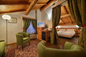 1 dormitorio con 1 cama y sillas en una habitación en Hotel Livigno, en Livigno