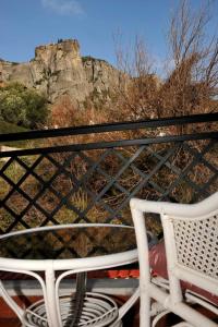 a white chair sitting in front of a mountain at Dominique Rooms Meteora in Kalabaka +7 photos