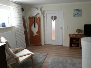 a living room with a chair and a door at Unner Deck aber schick in Stralsund