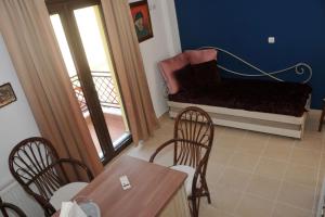 a living room with a couch and a table and chairs at Dominique Rooms Meteora in Kalabaka
