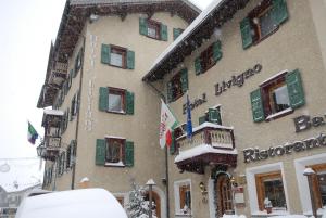 a building with green shuttered windows in the snow at Hotel Livigno in Livigno