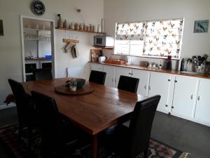 a kitchen with a wooden table and black chairs at Geduld in Prince Albert