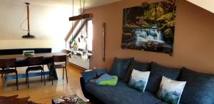 ein Wohnzimmer mit einem blauen Sofa und einem Tisch in der Unterkunft Ferienwohnung Wolfsschlucht in Calw