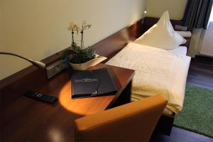 una camera d'albergo con scrivania, letto e scrivania di Hotel Brantl a Roding