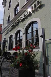 a building with flowers in front of a store at Hotel Brantl in Roding