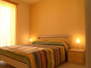 Un dormitorio con una cama con una manta colorida. en Donnafugata Relais, en Marina di Ragusa