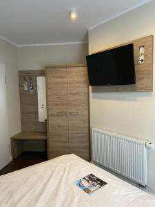 a bedroom with a bed and a flat screen tv on the wall at Akzent Hotel Saltenhof in Hörstel