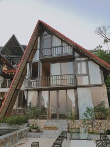 a house with glass windows and a balcony at Bách Xanh House. Nhà Đa Giác in Vĩnh Phúc