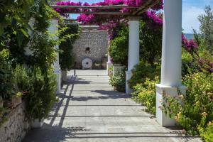 a walkway in a garden with pink flowers at Hotel Al Mulino in Anacapri