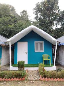 niebieski dom z namiotem nad drzwiami w obiekcie H7Stay Luxury Cottages And Camps, Rishikesh w mieście Rishikesh
