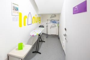 Zimmer mit einem Schreibtisch und einem Tisch in einem Zimmer in der Unterkunft Ibis Styles Lviv Center in Lwiw