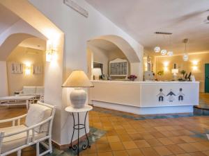 eine Lobby mit einem Wartebereich sowie einem Tisch und Stühlen in der Unterkunft Hotel Rocce Sarde in San Pantaleo