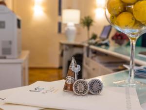 ein Paar Schlüssel auf einem Tisch neben einem Weinglas in der Unterkunft Hotel Rocce Sarde in San Pantaleo
