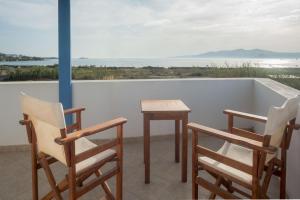a dining area with chairs, tables, chairs and umbrellas at Amodari studios on the beach in Plaka