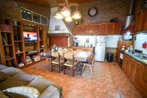 a kitchen with a table and chairs and a refrigerator at Casa en los troncos Parque Primavesi. in Mar del Plata