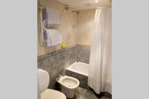 a bathroom with a toilet and a sink and a tub at Casa en los troncos Parque Primavesi. in Mar del Plata +20 photos