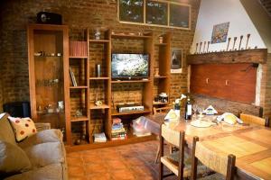 a living room with a wooden table and a television at Casa en los troncos Parque Primavesi. in Mar del Plata