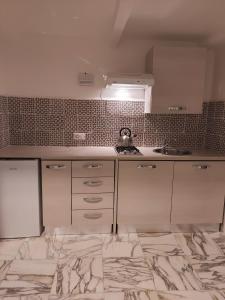 eine Küche mit weißen Schränken und einem Wasserkocher in der Unterkunft casa laurel in Meta