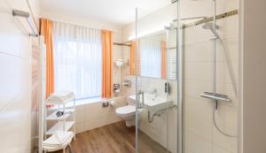 ein Bad mit einer Dusche, einem WC und einem Waschbecken in der Unterkunft Hotel Stadt Kappeln in Kappeln