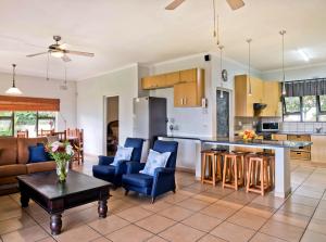 a kitchen and living room with blue chairs and a table at 6 Margaret in Scottburgh
