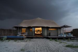 a small house with a large tent on the beach at Kingfisher Retreat by Sharjah Collection in Kalbā