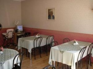 uma sala de jantar com mesas e cadeiras com toalhas de mesa brancas em Villa Marleen em Pärnu