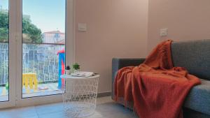 una manta sentada en un sofá en una habitación con ventana en Babyaccommodation Family Space, en Ceriale