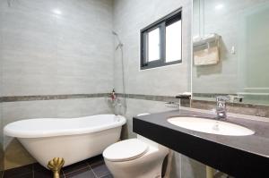 uma casa de banho com um WC branco e um lavatório. em 渡小夜電梯民宿 Yilannight B&B em Wujie