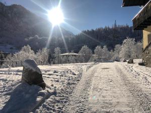 AlpinResort Kaprun 1 في كابرون: طريق مغطى بالثلج مع الشمس في الخلفية