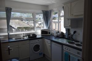a kitchen with a sink and a washing machine at Riverside 3 in Dartmouth