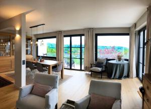 a large living room with a table and chairs at Vue exceptionnelle sur lac d'Annecy et Montagnes in Menthon-Saint-Bernard