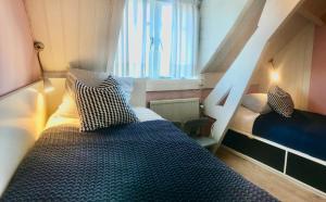 a small bedroom with a bed and a window at Vakantiehuis Dorpsplein in Koudekerke